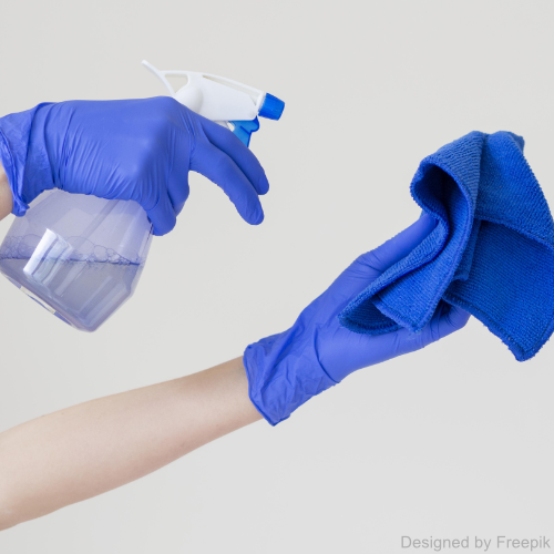 Eine Hand mit Handschuhen gibt Lösungsmittel für Wandfarbe auf ein Tuch.