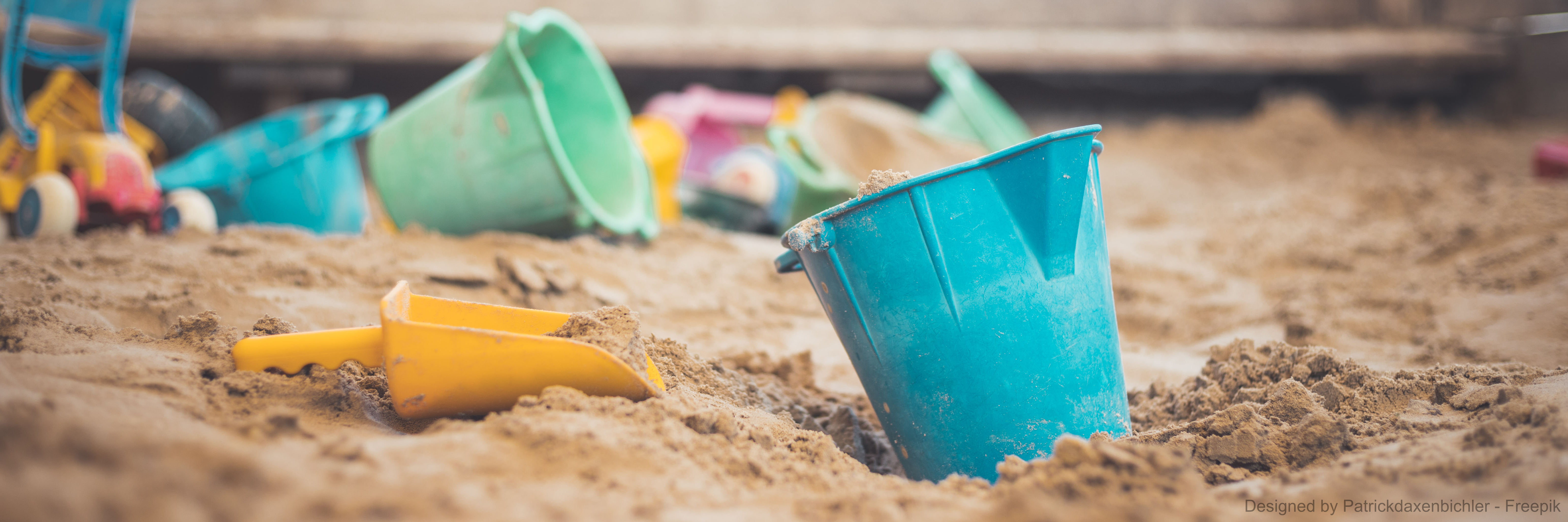 Bunte Spielsachen in einem Sandkasten