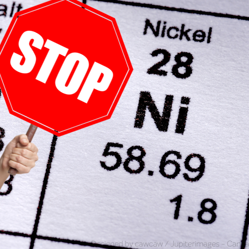 Eine Hand hält ein Stoppschild vor das Element Nickel in einem Periodensystem.