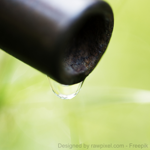 Ein Tropfen Wasser läuft aus dem Wasserhahn eines Hausbrunnens. 