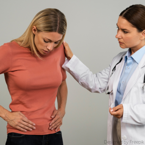 Eine Ärztin legt ihre Hand auf die Schulter einer Patientin, die Unterleibsschmerzen aufgrund einer Harnwegsinfektion durch E. coli hat.