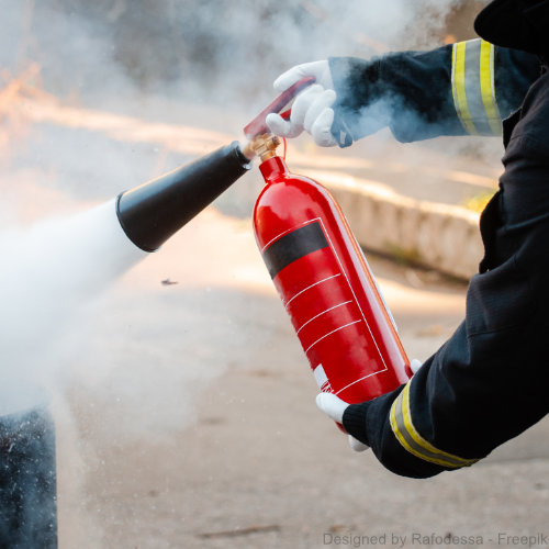 Ein Feuerwehrmann nutzt einen Feuerlöscher.