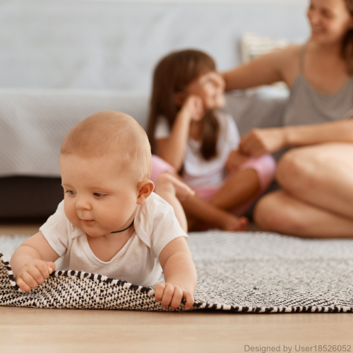 Ein Baby krabbelt über einen Teppich.