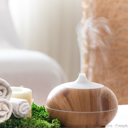 Ein Vernebler in einem hellen Zimmer neben gerollten Handtüchern und einer Kerze