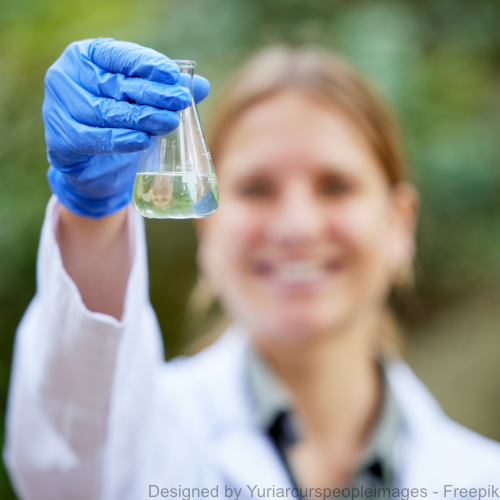 Eine Forscherin untersucht eine Wasserprobe im Freien. 