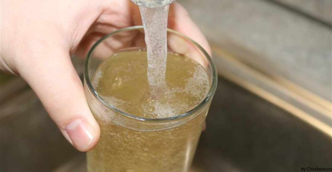 Trübes Leitungswasser fließt aus dem Wasserhahn in ein Glas