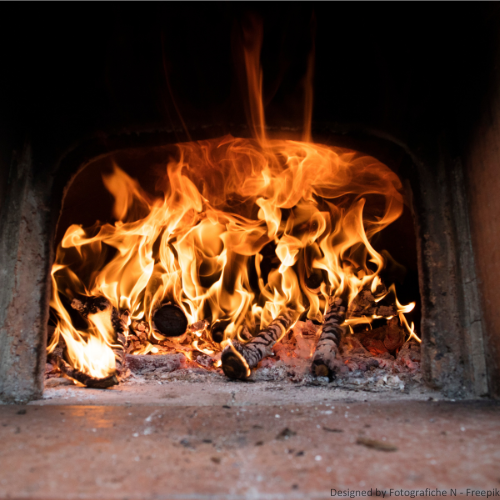 Asbesthaltiger Kamin Ein mit Asbestzement gebauter Kamin, in dem ein Feuer brennt.