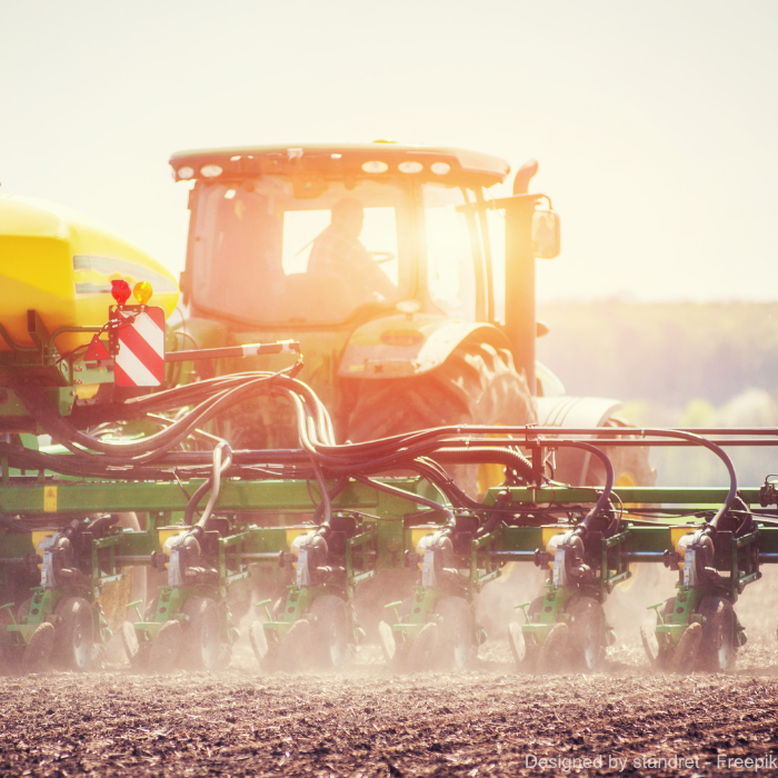 Ein Traktor bestellt das Feld bei Sonnenunterhang