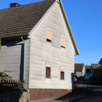 Ein Haus mit einer Fassade aus Asbestschindeln
