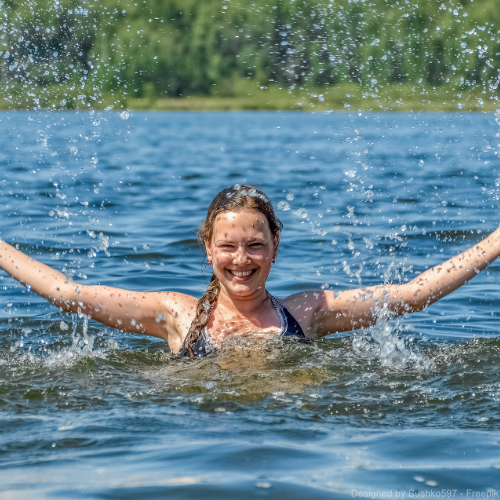 Eine junge Frau planscht in einem Fluss